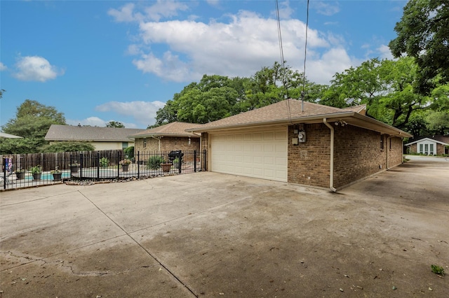 exterior space with brick siding, fence, and driveway