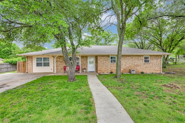 view of front of home with brick siding, fence, and a front lawn