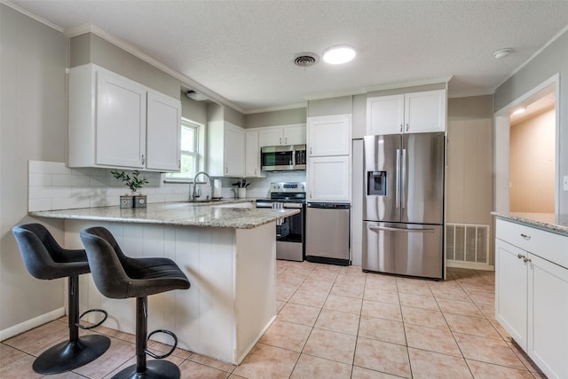 kitchen with a sink, appliances with stainless steel finishes, decorative backsplash, and visible vents