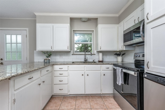 kitchen with a sink, stainless steel appliances, a textured ceiling, and white cabinetry