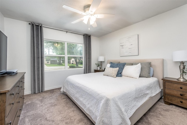 bedroom with light colored carpet, a ceiling fan, and baseboards