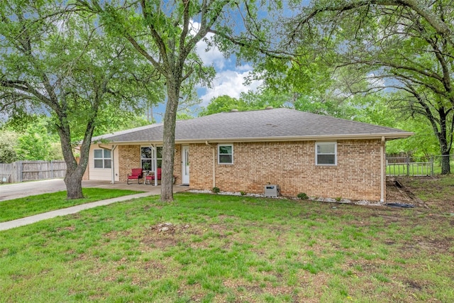 view of front of house with fence, a patio, a front lawn, and brick siding