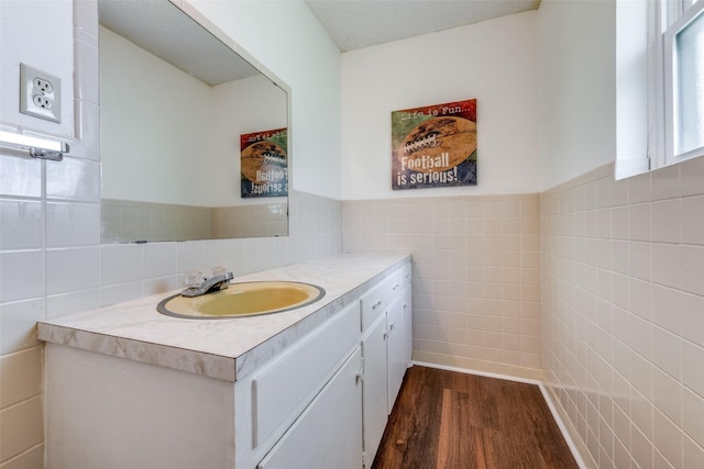 bathroom featuring tile walls, wainscoting, wood finished floors, and vanity