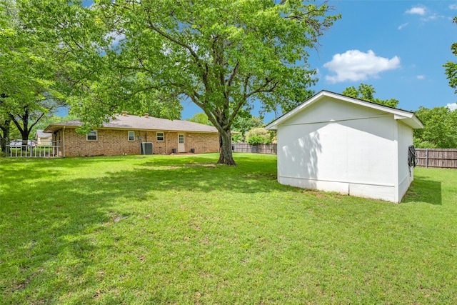view of yard featuring fence and central AC
