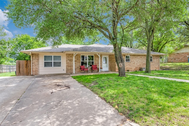 ranch-style house with brick siding, fence, driveway, and a front yard