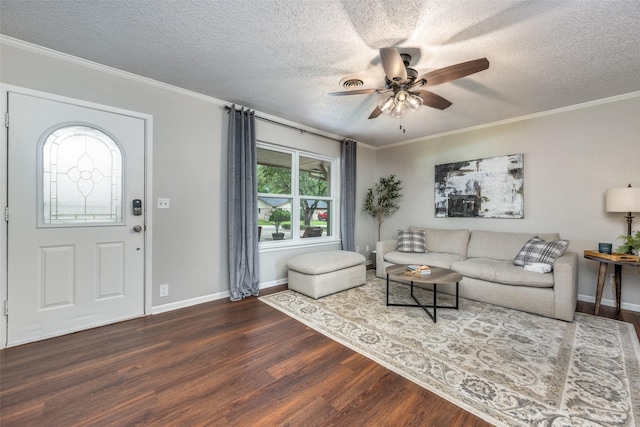 living area with ornamental molding, wood finished floors, baseboards, ceiling fan, and a textured ceiling