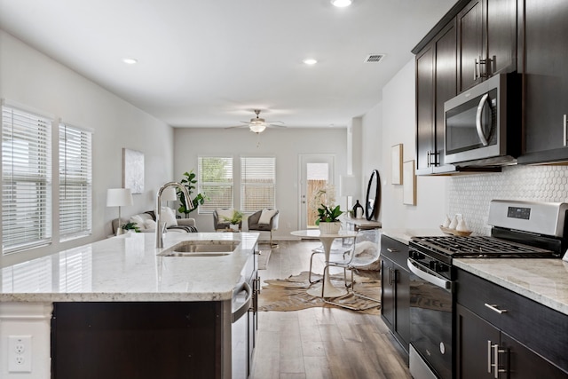 2021 Pine Stone Ln, Forney, TX 75126 - kitchen featuring light wood-style floors, open floor plan, ceiling fan, a sink, and appliances with stainless steel finishes