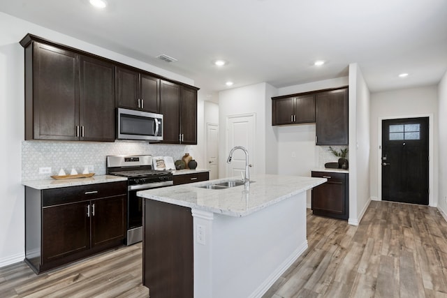 2021 Pine Stone Ln, Forney, TX 75126 - kitchen featuring appliances with stainless steel finishes, a sink, light wood-style floors, backsplash, and visible vents