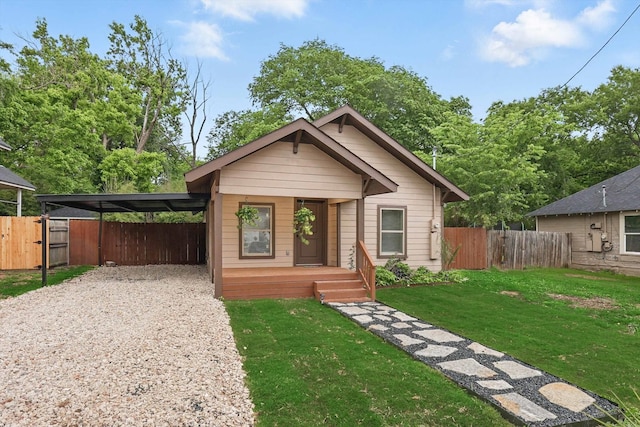 217 N Hawkins St, Waxahachie, TX 75165 - bungalow with fence, covered porch, a front yard, gravel driveway, and an attached carport