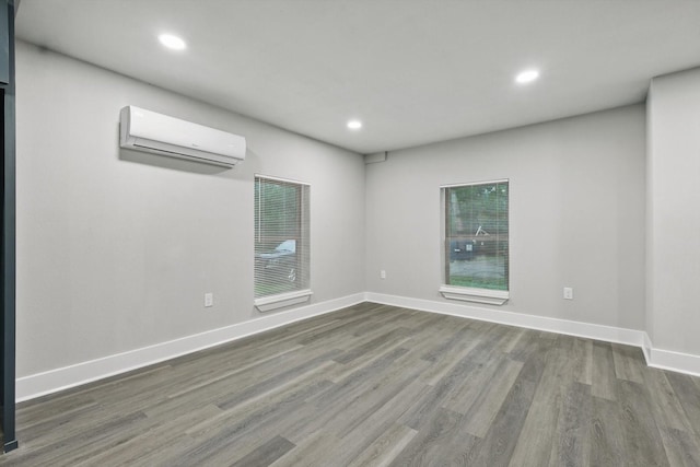 217 N Hawkins St, Waxahachie, TX 75165 - empty room featuring an AC wall unit, baseboards, recessed lighting, and wood finished floors