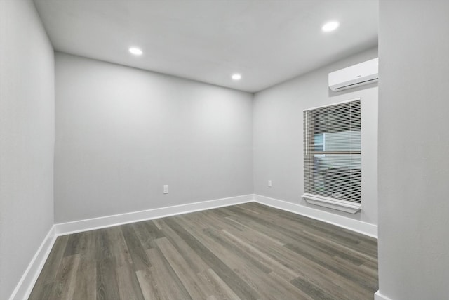 217 N Hawkins St, Waxahachie, TX 75165 - unfurnished room with baseboards, recessed lighting, a wall mounted air conditioner, and wood finished floors