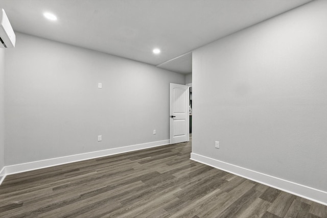 217 N Hawkins St, Waxahachie, TX 75165 - unfurnished room with baseboards, recessed lighting, a wall unit AC, and dark wood-style floors