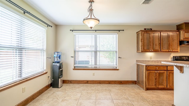 630 N Park St, Dublin, TX 76446 - kitchen with brown cabinets, ventilation hood, light countertops, and baseboards