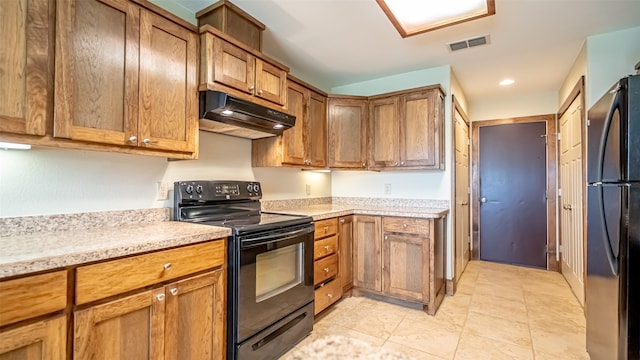 630 N Park St, Dublin, TX 76446 - kitchen with black electric range oven, under cabinet range hood, freestanding refrigerator, light countertops, and brown cabinetry