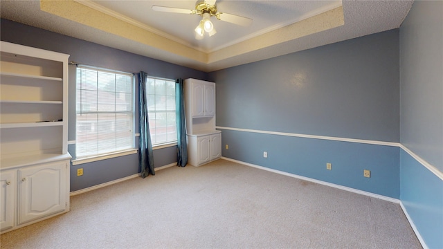 empty room with crown molding, baseboards, light carpet, and ceiling fan
