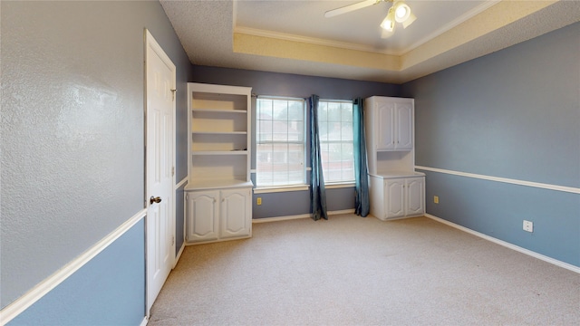 empty room featuring a ceiling fan, baseboards, light colored carpet, and ornamental molding