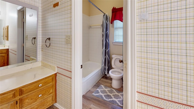 full bath with vanity, toilet, shower / bathtub combination with curtain, wallpapered walls, and wood finished floors