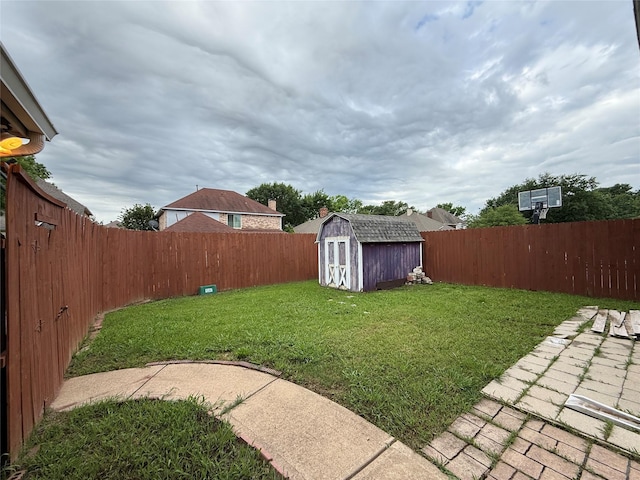 view of yard with an outdoor structure, a fenced backyard, and a shed