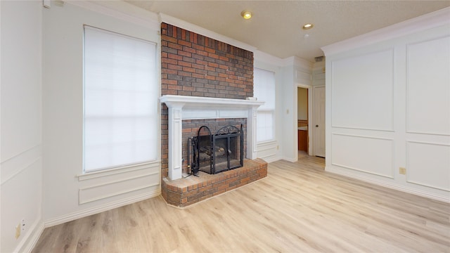 unfurnished living room with baseboards, recessed lighting, wood finished floors, and a fireplace