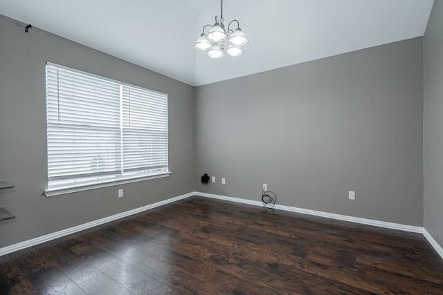 empty room with an inviting chandelier, dark wood-style flooring, baseboards, and vaulted ceiling