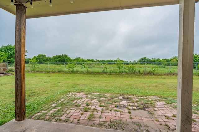 view of yard featuring a rural view, fence, and a patio area