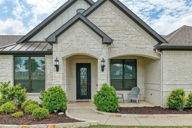 235 Winchester St, Van Alstyne, TX 75495 - doorway to property featuring covered porch, stone siding, a standing seam roof, a shingled roof, and board and batten siding
