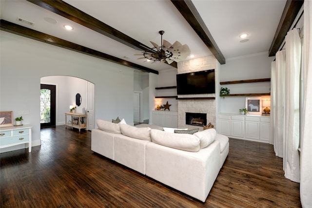 235 Winchester St, Van Alstyne, TX 75495 - living room with arched walkways, dark wood-style floors, beam ceiling, and a fireplace