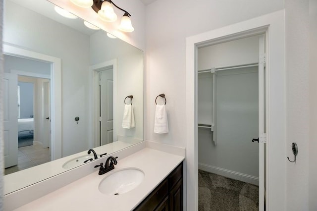 235 Winchester St, Van Alstyne, TX 75495 - bathroom featuring baseboards, a walk in closet, and vanity
