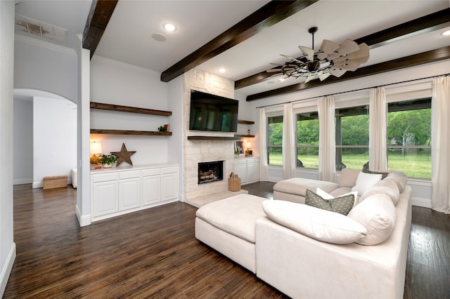 235 Winchester St, Van Alstyne, TX 75495 - living room featuring visible vents, beam ceiling, a fireplace, arched walkways, and dark wood finished floors
