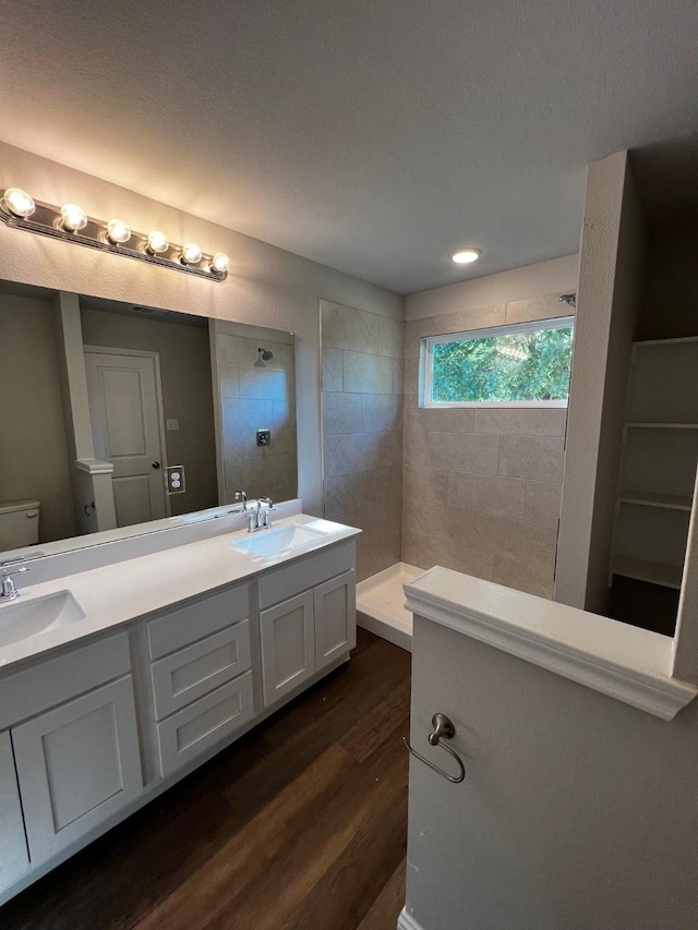 7935 Hull Ave, Dallas, TX 75216 - bathroom featuring a sink, a walk in shower, double vanity, and wood finished floors