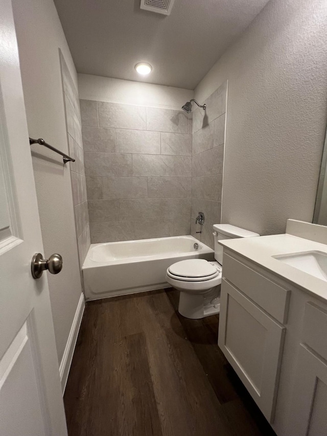7935 Hull Ave, Dallas, TX 75216 - bathroom featuring vanity, toilet, tub / shower combination, wood finished floors, and visible vents