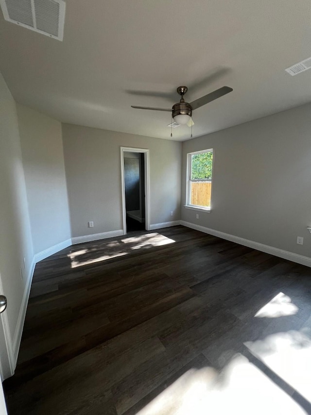 7935 Hull Ave, Dallas, TX 75216 - unfurnished room with visible vents, a ceiling fan, baseboards, and dark wood-style floors