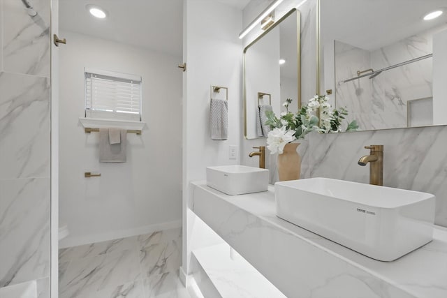 bathroom featuring marble finish flooring, a marble finish shower, recessed lighting, and double vanity