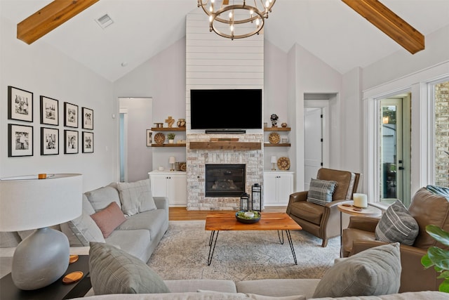 living room with visible vents, wood finished floors, beamed ceiling, high vaulted ceiling, and a chandelier