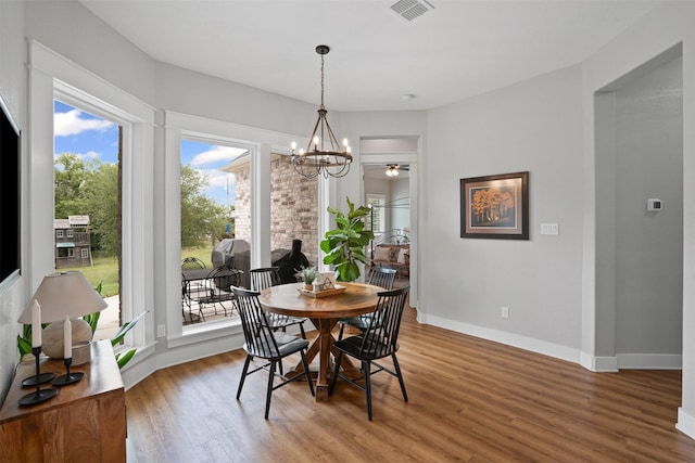 dining room with visible vents, light wood-style flooring, baseboards, and an inviting chandelier