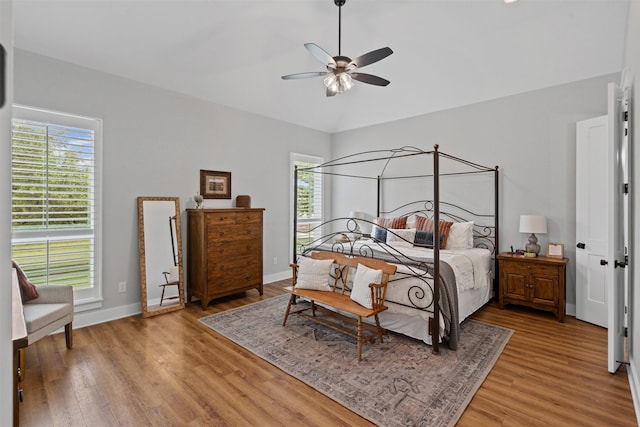 bedroom with baseboards, a ceiling fan, vaulted ceiling, and light wood-type flooring