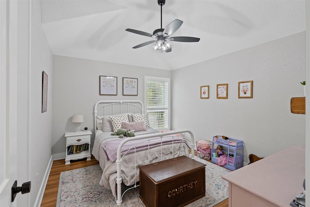 bedroom featuring ceiling fan, baseboards, vaulted ceiling, and wood finished floors
