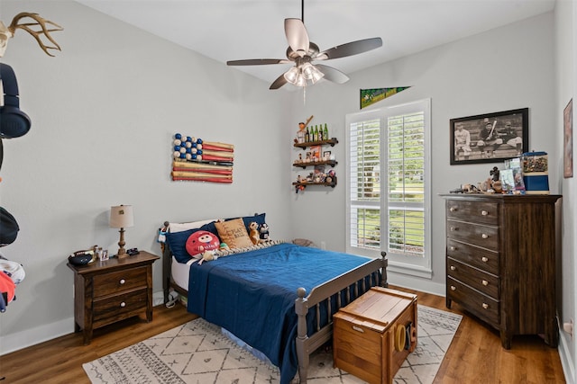 bedroom with light wood-style floors, baseboards, and a ceiling fan