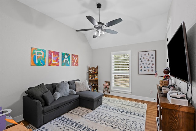 living area featuring baseboards, light wood-style flooring, ceiling fan, and lofted ceiling