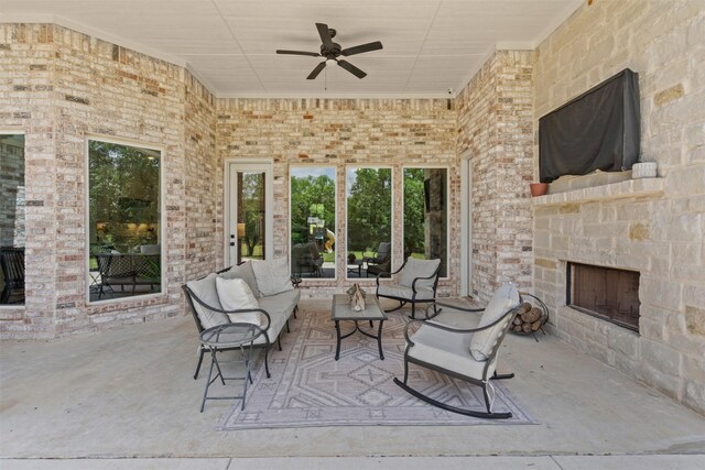 view of patio / terrace with a ceiling fan and an outdoor living space with a fireplace