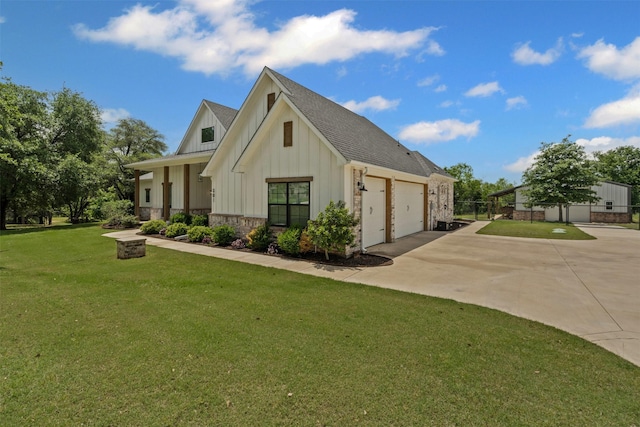 view of front of home featuring a shingled roof, an attached garage, board and batten siding, a front yard, and concrete driveway