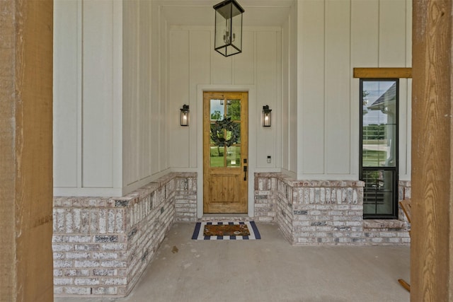 doorway to property with board and batten siding and stone siding