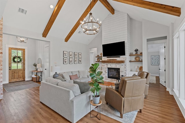 living area with light wood-style floors, high vaulted ceiling, a chandelier, and visible vents