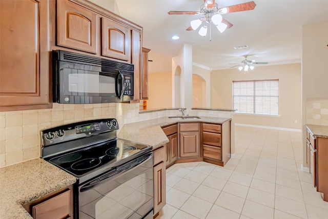 kitchen featuring ceiling fan, light stone countertops, a sink, decorative backsplash, and black appliances