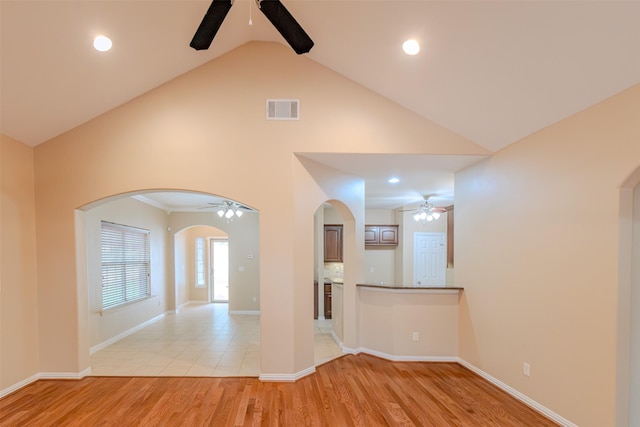 empty room with arched walkways, ceiling fan, high vaulted ceiling, and visible vents