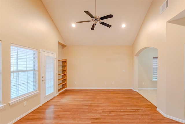 spare room with high vaulted ceiling, a ceiling fan, arched walkways, and visible vents