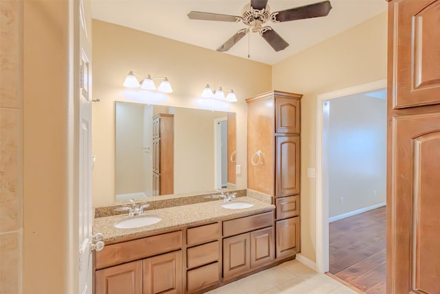 bathroom with double vanity, a sink, baseboards, and ceiling fan