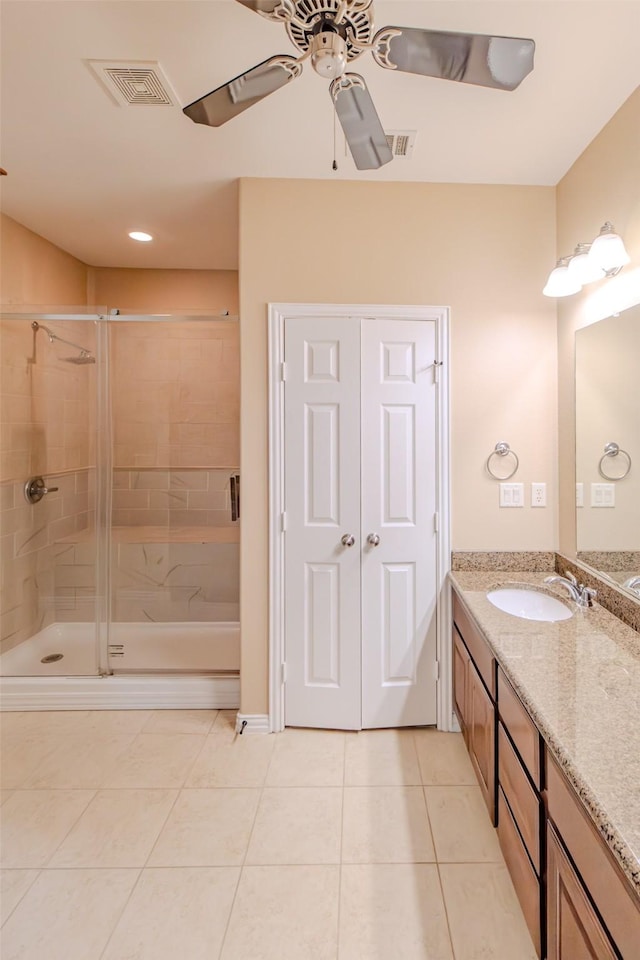 full bathroom featuring ceiling fan, visible vents, a shower stall, and tile patterned floors
