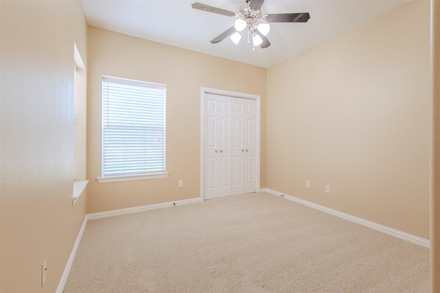 unfurnished bedroom featuring carpet flooring, a ceiling fan, baseboards, and a closet