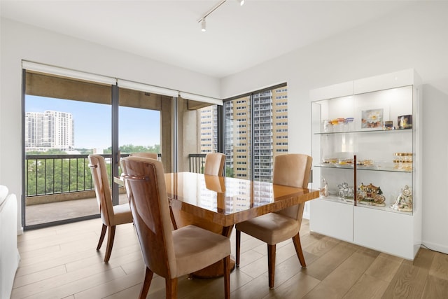 3831 Turtle Creek Blvd Unit 7E, Dallas, TX 75219 - dining area with light wood-style floors and rail lighting
